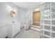 Bathroom with glass block shower, white vanity, and checkered floor at 318 Vermont Ave, Daytona Beach, FL 32118