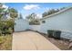 Driveway leading to a detached garage with trash bins and landscaping at 318 Vermont Ave, Daytona Beach, FL 32118