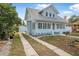 Light blue two-story beach house with a metal roof, driveway, and white picket fence at 318 Vermont Ave, Daytona Beach, FL 32118