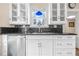 Kitchen boasts white cabinetry, dark granite countertops, and a stainless steel dishwasher at 318 Vermont Ave, Daytona Beach, FL 32118