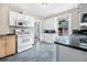 Kitchen with white cabinets, dark countertops, and white appliances at 318 Vermont Ave, Daytona Beach, FL 32118