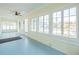 Bright sunroom with light blue painted floors and numerous windows providing ample natural light at 318 Vermont Ave, Daytona Beach, FL 32118