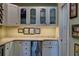 White butler's pantry with glass-front cabinets, quartz countertops, and under-cabinet lighting at 546 Rio Vista Ave, Daytona Beach, FL 32114