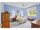 Light blue bedroom with a twin bed, wooden dresser, and large window at 1333 Asher Ct # 1333, Ormond Beach, FL 32174