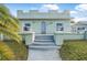 Front view of a charming light green house with crenelations and a walkway at 328 Manhattan Ave, Daytona Beach, FL 32118