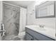 Bathroom with marble tile shower, gray vanity, and white countertop at 53 Ocean Palm Villa S # 53, Flagler Beach, FL 32136