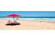 Relax on the sandy beach with lounge chairs and a red umbrella, perfect for enjoying the ocean view at 53 Ocean Palm Villa S # 53, Flagler Beach, FL 32136