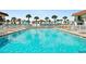 Community pool with lounge chairs and palm trees at 53 Ocean Palm Villa S # 53, Flagler Beach, FL 32136