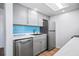 Updated kitchen with stainless steel appliances, gray cabinets, and blue tile backsplash at 53 Ocean Palm Villa S # 53, Flagler Beach, FL 32136