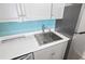 Close-up of the stainless steel sink, faucet, and blue tile backsplash in the kitchen at 53 Ocean Palm Villa S # 53, Flagler Beach, FL 32136