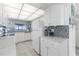 Modern kitchen with white cabinets, granite counters, and ocean view at 89 S Atlantic Ave # 1401, Ormond Beach, FL 32176