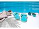Poolside view with towel, sunglasses, and flip-flops at 89 S Atlantic Ave # 1401, Ormond Beach, FL 32176