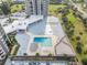 Drone view showing condo building pool, shuffleboard, and parking at 1 Oceans West Blvd # 5B3, Daytona Beach, FL 32118