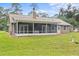 Large backyard with screened porch and spacious grassy area at 63 Village Dr, Ormond Beach, FL 32174