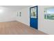 Room featuring light wood floors, white walls and blue door at 1448 Richmond Ave, Daytona Beach, FL 32117