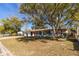 White house with red door and large tree in front at 1703 Hill St, Edgewater, FL 32132