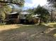 Two-story house with metal roof, surrounded by lush trees at 2436 Cr 416N, Lake Panasoffkee, FL 33538