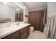 Bathroom with brown shower curtain, dark wood vanity, and white tile flooring at 9701 E Warm Springs Ave, Coleman, FL 33521