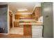 Mid-century kitchen features wood cabinets, tile countertops, and a built-in dishwasher at 9701 E Warm Springs Ave, Coleman, FL 33521