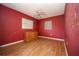 Simple bedroom with red walls, wood flooring, and a dresser at 9701 E Warm Springs Ave, Coleman, FL 33521