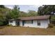 Ranch style home with white exterior and dark door at 9701 E Warm Springs Ave, Coleman, FL 33521