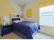 Serene bedroom in navy and yellow, featuring a wooden headboard and window at 9105 Cape Cod Rd, Deland, FL 32724