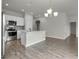 Modern kitchen with island, stainless steel appliances, and wood-look tile floors at 429 Silver Palm Dr, Haines City, FL 33844