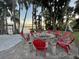 Cozy lakeside fire pit with red Adirondack chairs at 1241 W Lakeshore Dr, Clermont, FL 34711