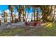 Lakefront fire pit surrounded by red chairs under the trees at 1241 W Lakeshore Dr, Clermont, FL 34711