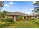 House backyard with lush green grass and hedge at 5418 Meadow Hill Loop, Lady Lake, FL 32159