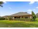 House backyard with lush green grass and hedge at 5418 Meadow Hill Loop, Lady Lake, FL 32159