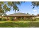 House backyard with lush green grass and hedge at 5418 Meadow Hill Loop, Lady Lake, FL 32159
