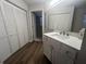 Clean bathroom with updated vanity and flooring, plus a view into another room at 7874 Midway Drive Ter # V101, Ocala, FL 34472