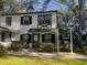 Two-story duplex with white exterior, black trim, and landscaping at 7874 Midway Drive Ter # V101, Ocala, FL 34472