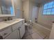 Updated bathroom with white vanity, new bathtub, and tile floor at 7874 Midway Drive Ter # V101, Ocala, FL 34472