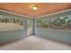 Cozy screened porch with wood ceiling, concrete floor, and access to yard at 21342 S Buckhill Rd, Clermont, FL 34715