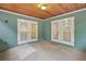 Screened porch with wood ceiling, concrete floor, and double doors at 21342 S Buckhill Rd, Clermont, FL 34715