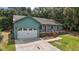 Quaint house featuring a white garage door and wooden deck at 21342 S Buckhill Rd, Clermont, FL 34715