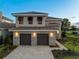 Two-story house with two-car garage and landscaping at 15942 Vetta Dr, Bella Collina, FL 34756