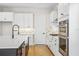 Modern kitchen with white cabinets, quartz countertops and a farmhouse sink at 15623 Vetta Dr, Montverde, FL 34756