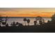 Scenic sunset over calm lake water with palm trees and fence at 671 James Moore Dr, Mount Dora, FL 32757
