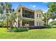 Two-story house with screened balcony, lush landscaping, and a manicured lawn at 26142 Avenida Las Colinas # 2B, Howey In The Hills, FL 34737