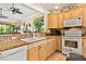 Bright kitchen featuring white appliances, granite countertops, and ample cabinetry at 26142 Avenida Las Colinas # 2B, Howey In The Hills, FL 34737