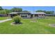 Ranch-style home with carport and manicured lawn at 9930 County Road 114B, Wildwood, FL 34785