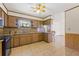 Kitchen features wood cabinets, granite countertops, and a breakfast bar at 9930 County Road 114B, Wildwood, FL 34785
