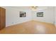 Bright bedroom featuring light wood flooring and ceiling fan at 9930 County Road 114B, Wildwood, FL 34785