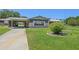 Ranch-style home with carport and manicured lawn at 9930 County Road 114B, Wildwood, FL 34785