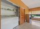 Bright laundry room with washer, dryer, and built-in shelving at 9930 County Road 114B, Wildwood, FL 34785