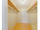 Large walk-in closet with wood shelving and flooring at 9930 County Road 114B, Wildwood, FL 34785