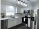 Modern kitchen with white cabinets, stainless steel appliances, and quartz countertops at 1921 Smitty Rd, Lady Lake, FL 32159